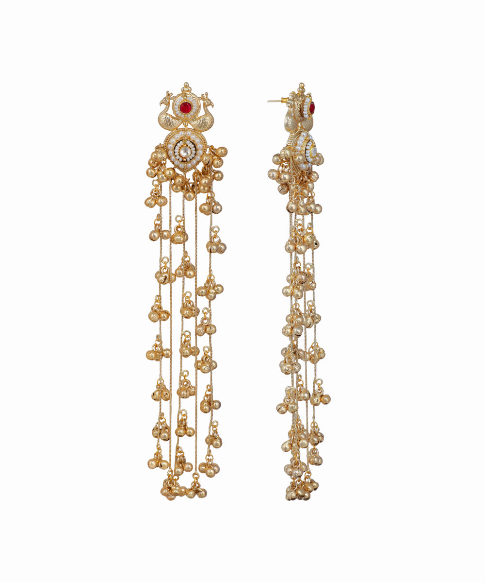 Gold earrings with intricate designs and red gemstones on a white background