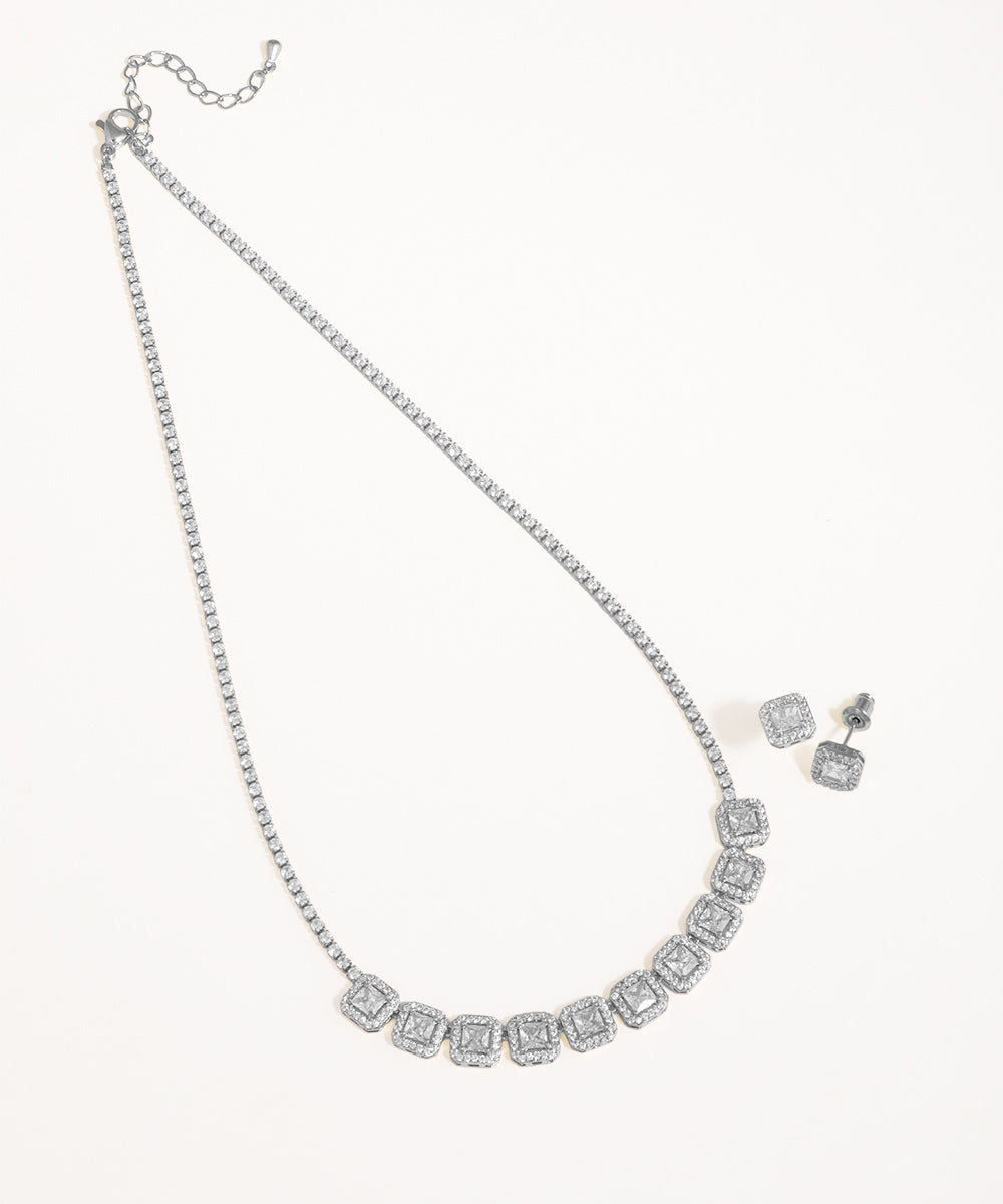 Silver necklace and earrings set on a white background
