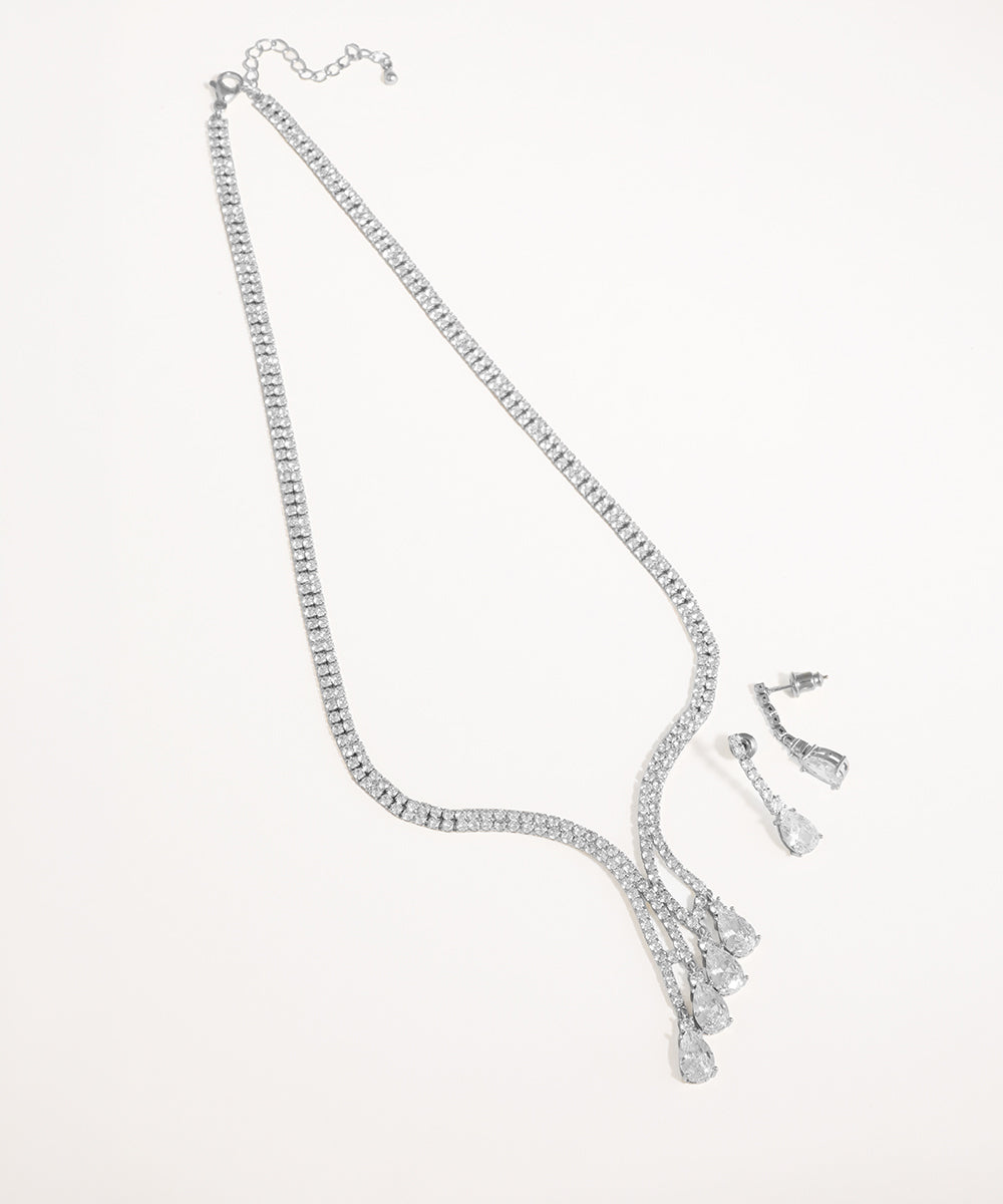 Silver necklace and earrings set on a white background