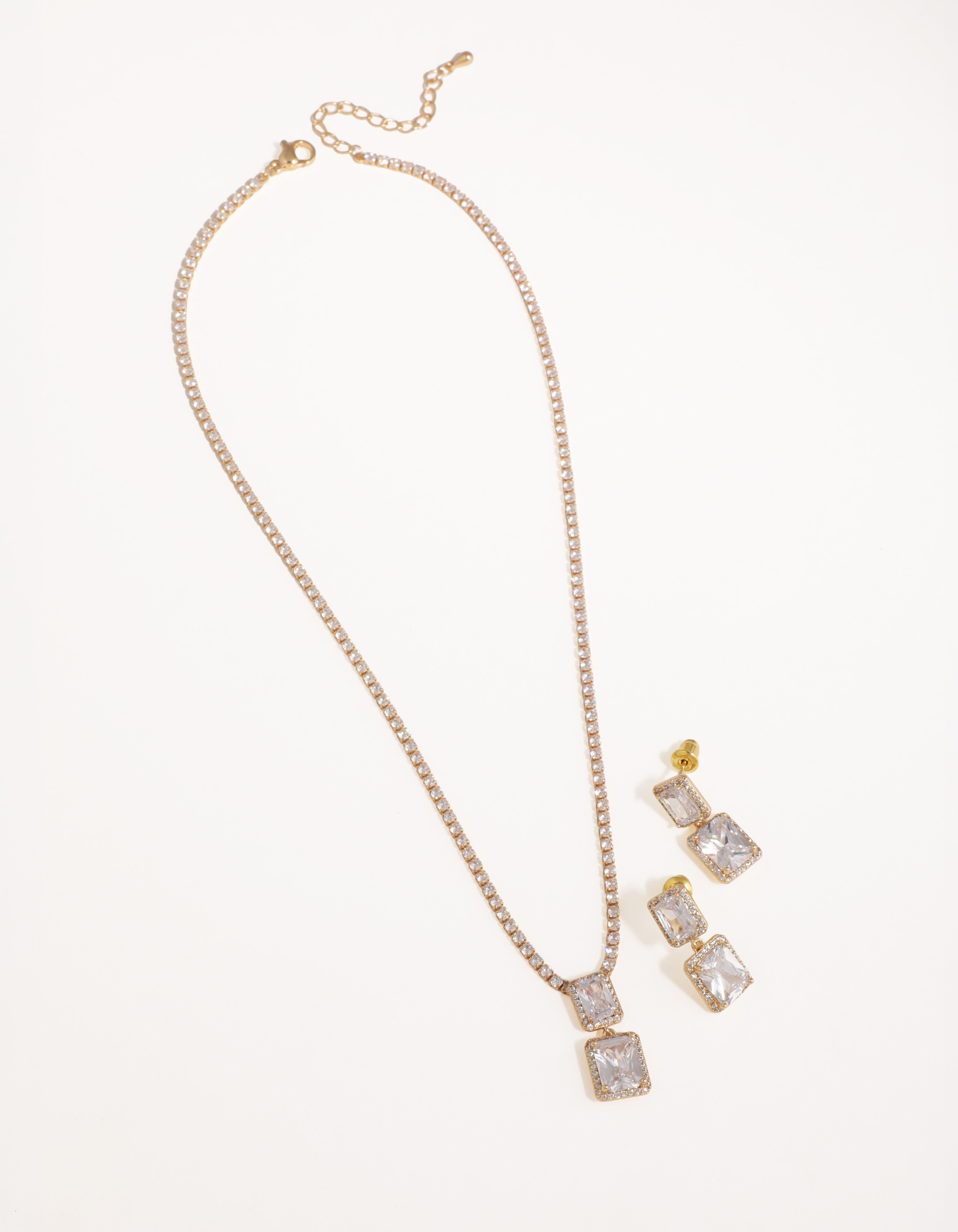 Gold necklace and earrings set on a white background