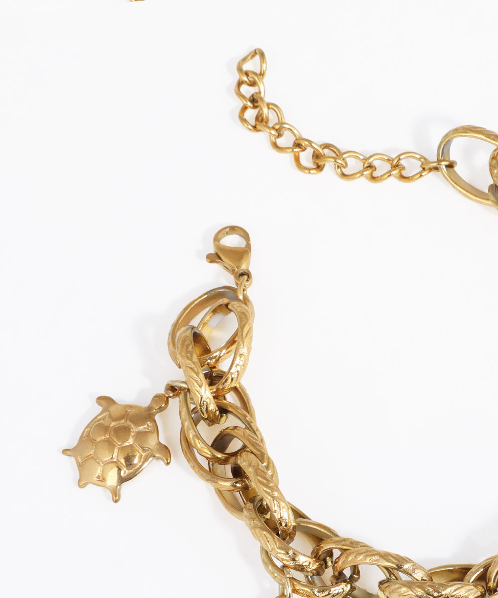 Gold bracelet with a turtle charm on a white background