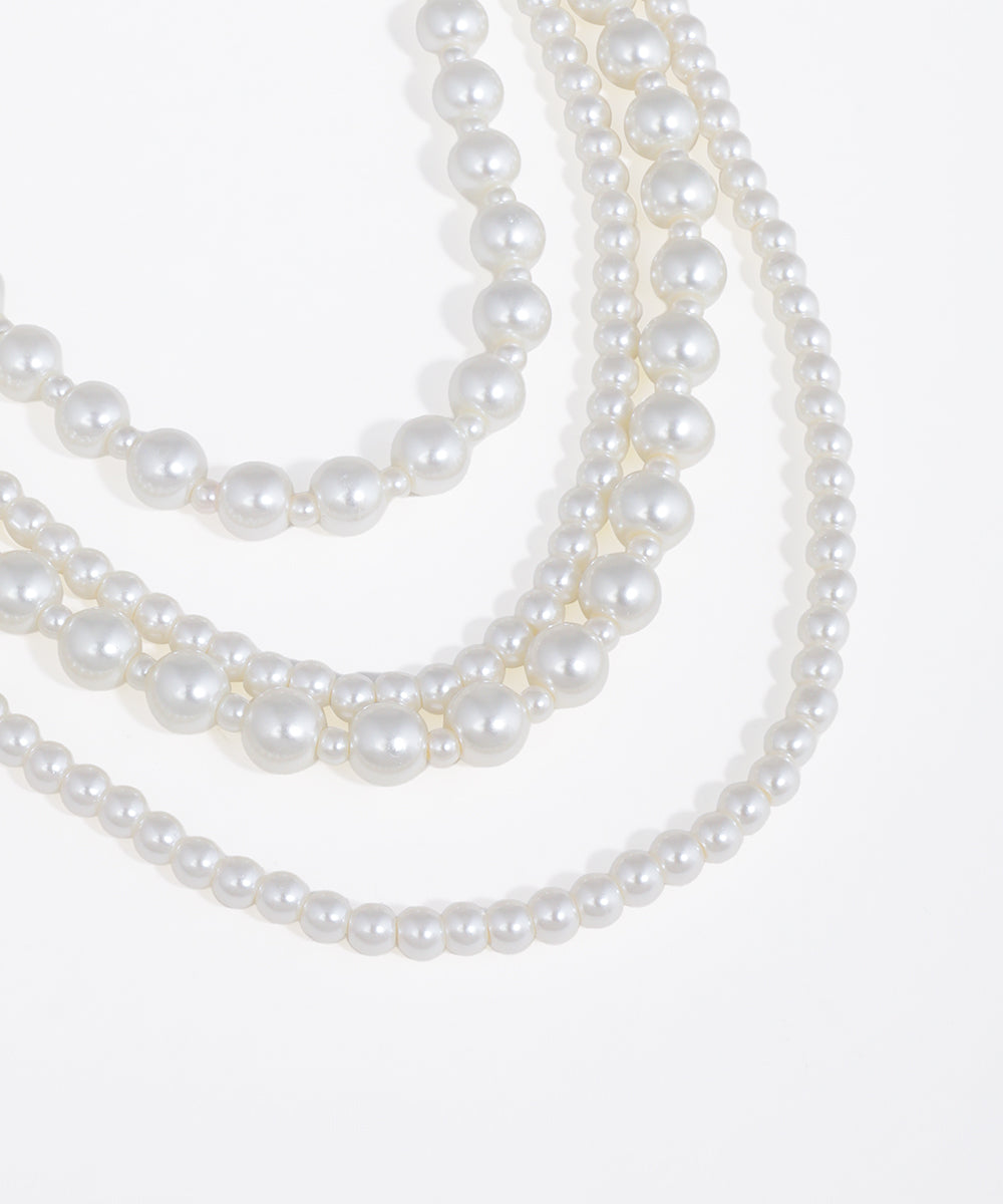 Three strands of pearls on a white background