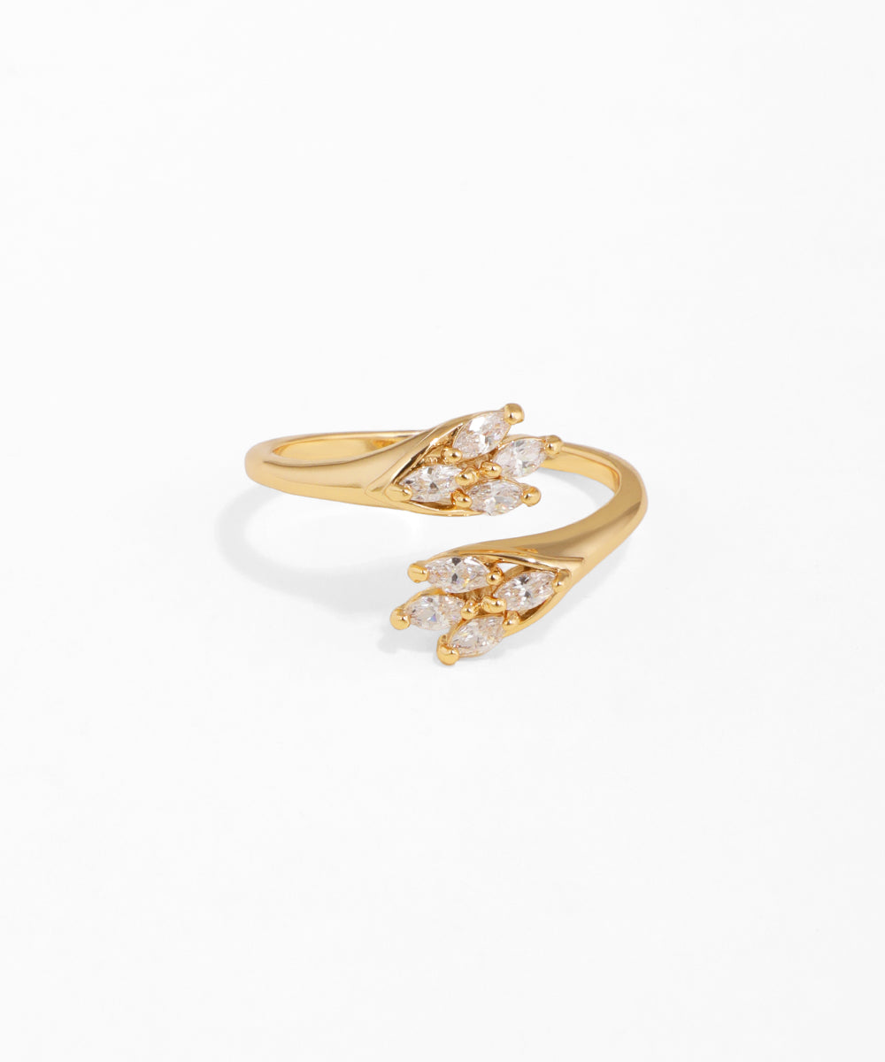 Gold open ring with diamond-like stones on a white background