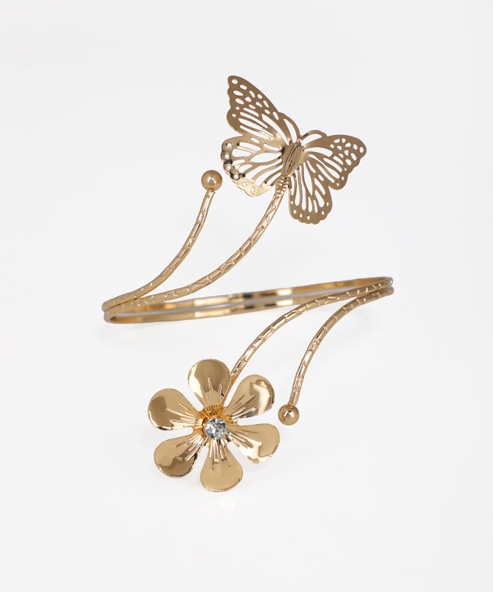 Gold bracelet with butterfly and flower design on a white background
