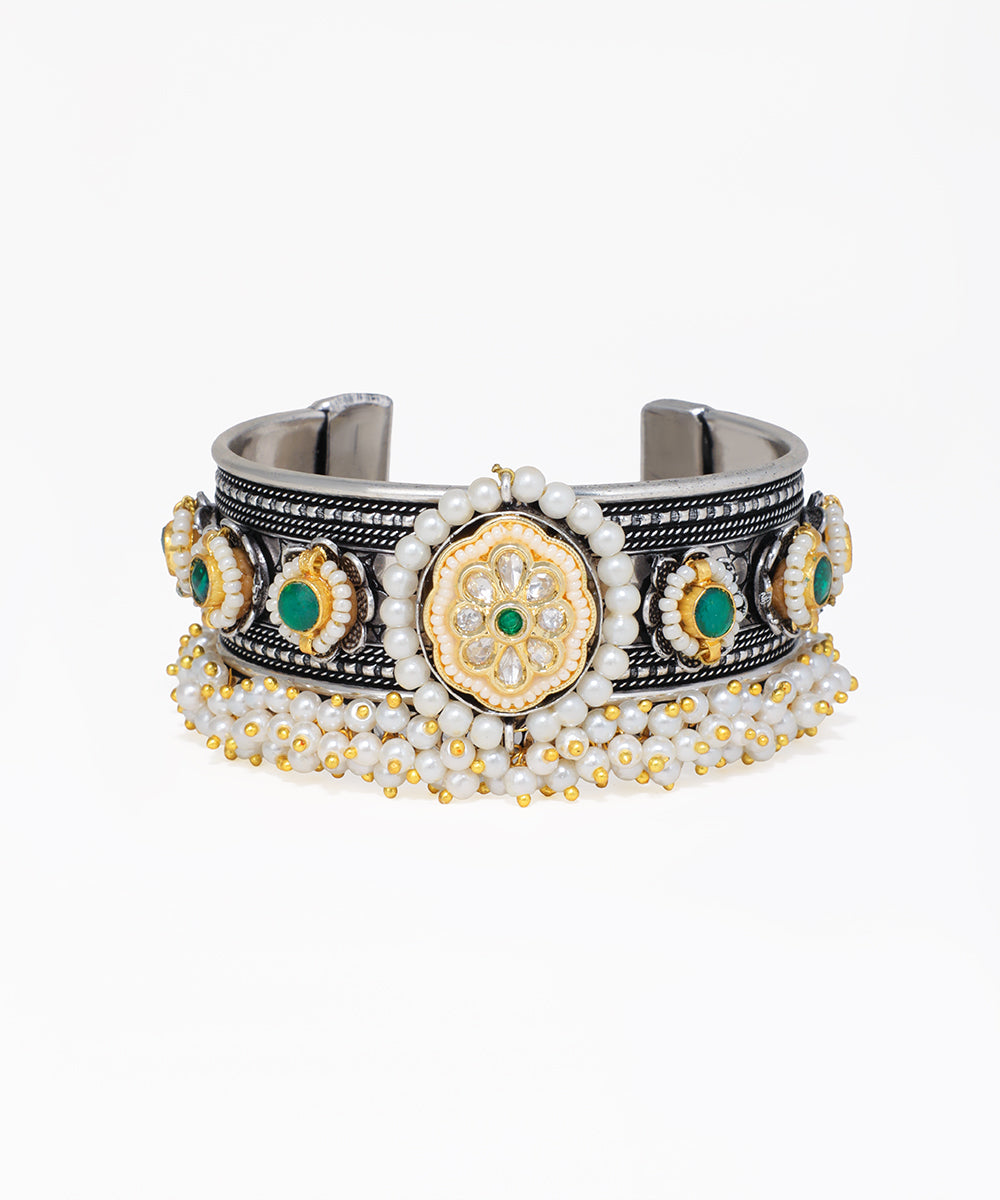 Decorative bracelet with gold, silver, and green elements on a white background