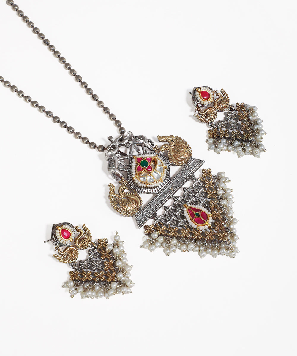 Ornate necklace and earrings with intricate designs on a white background