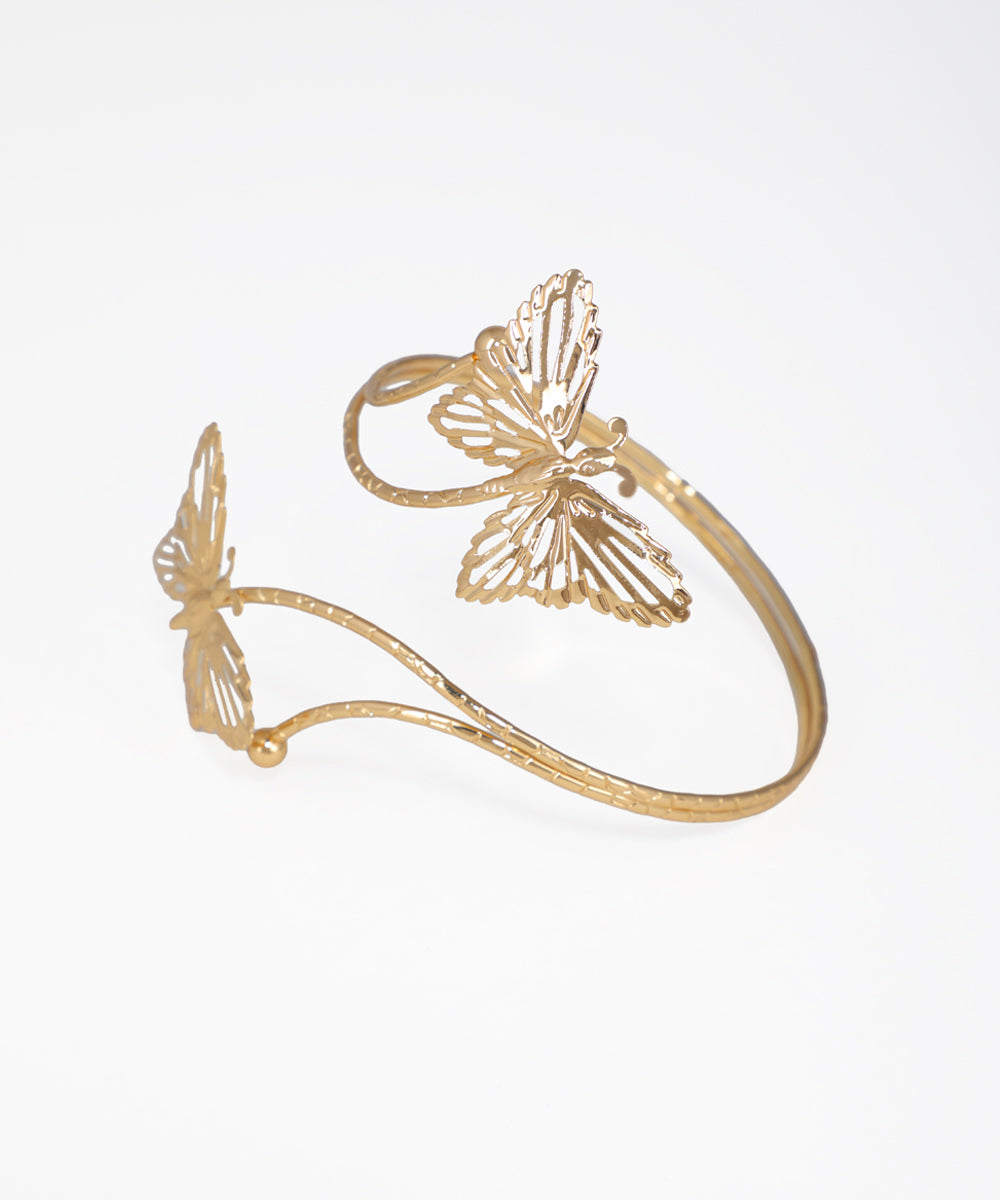 Gold butterfly-shaped bracelet on a white background