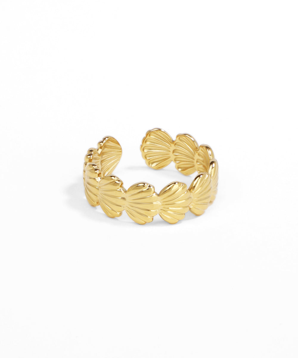 Gold shell-shaped ring on a white background
