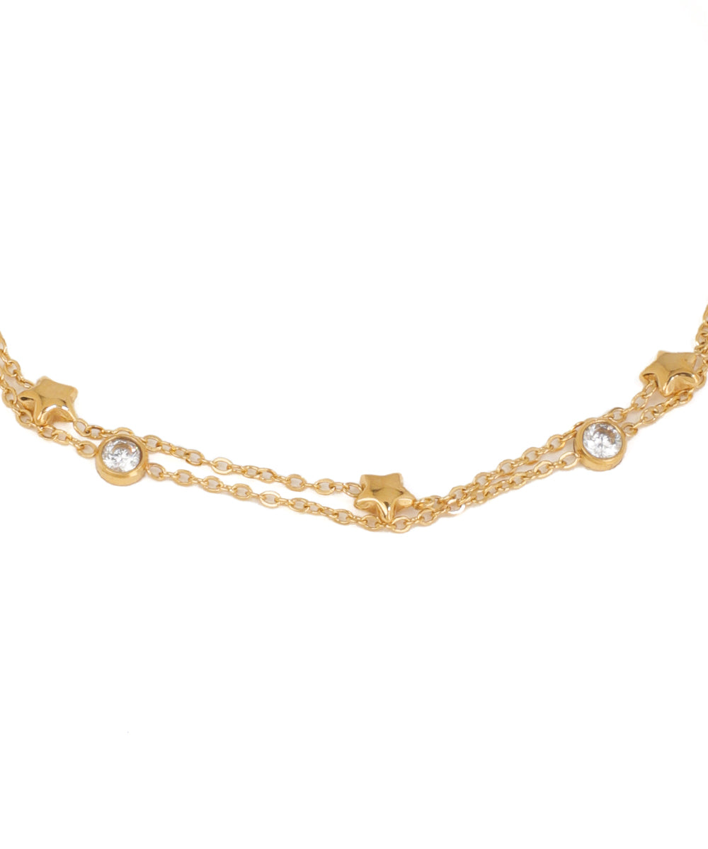 Gold chain necklace with star and gemstone details on a white background