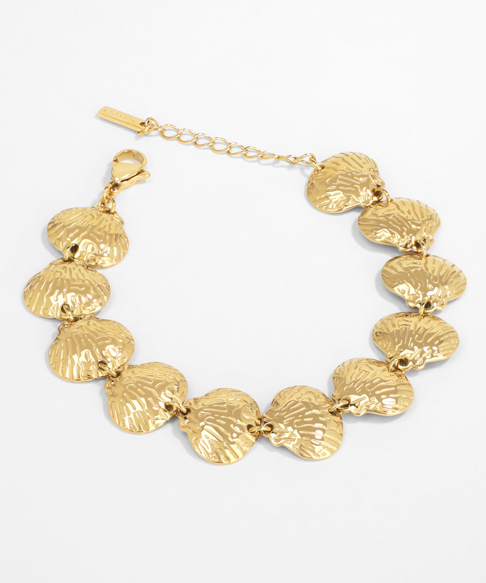 Gold bracelet with shell-like links on a white background