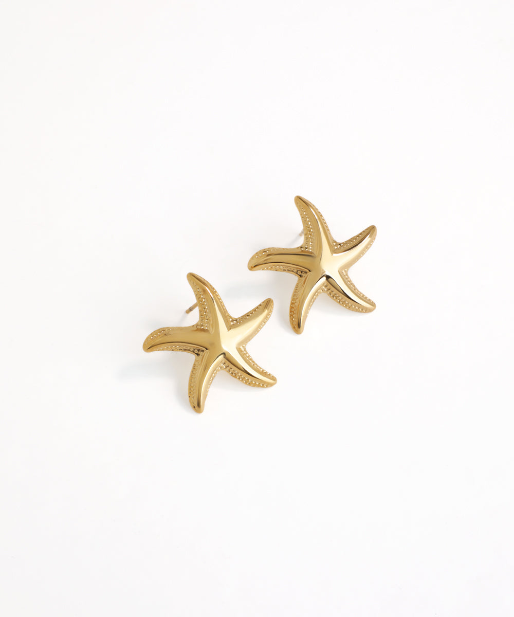 Gold starfish earrings on a white background