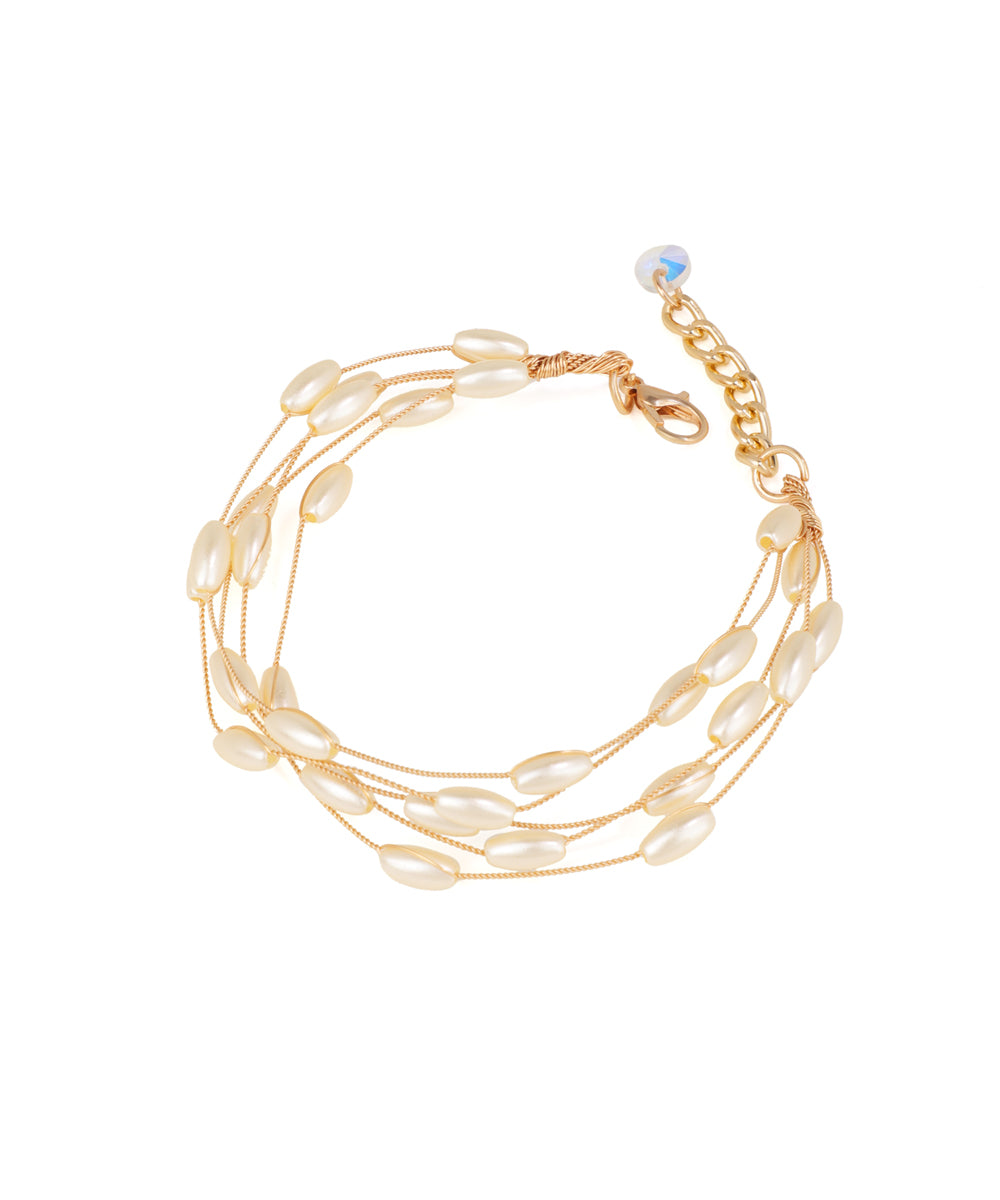 Gold-tone layered chain bracelets with elongated faux pearls and a small iridescent crystal on the extender.