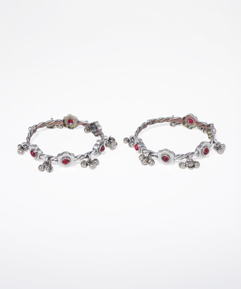 Pair of hoop earrings with red gemstones on a white background