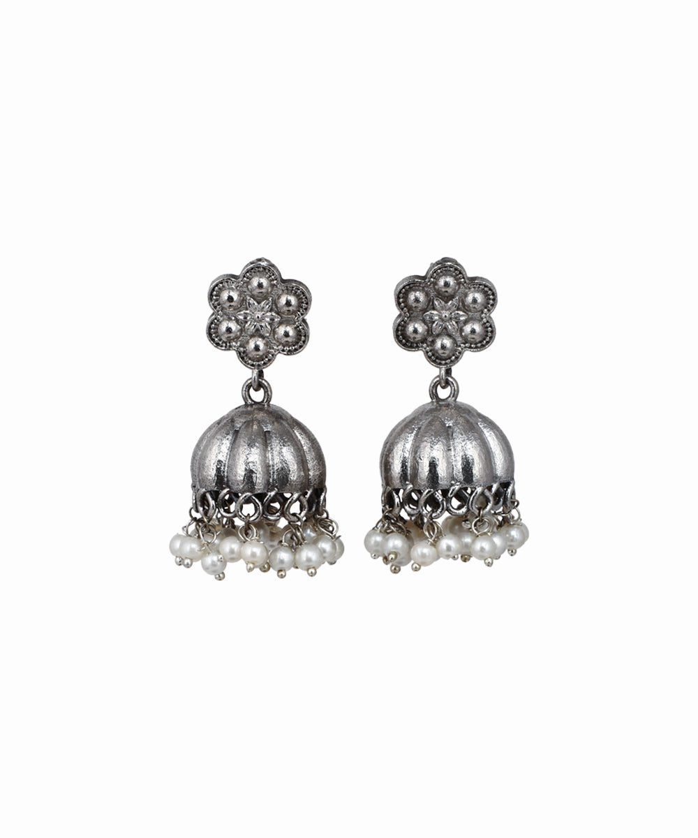 Pair of silver jhumka earrings with pearl drops on a white background