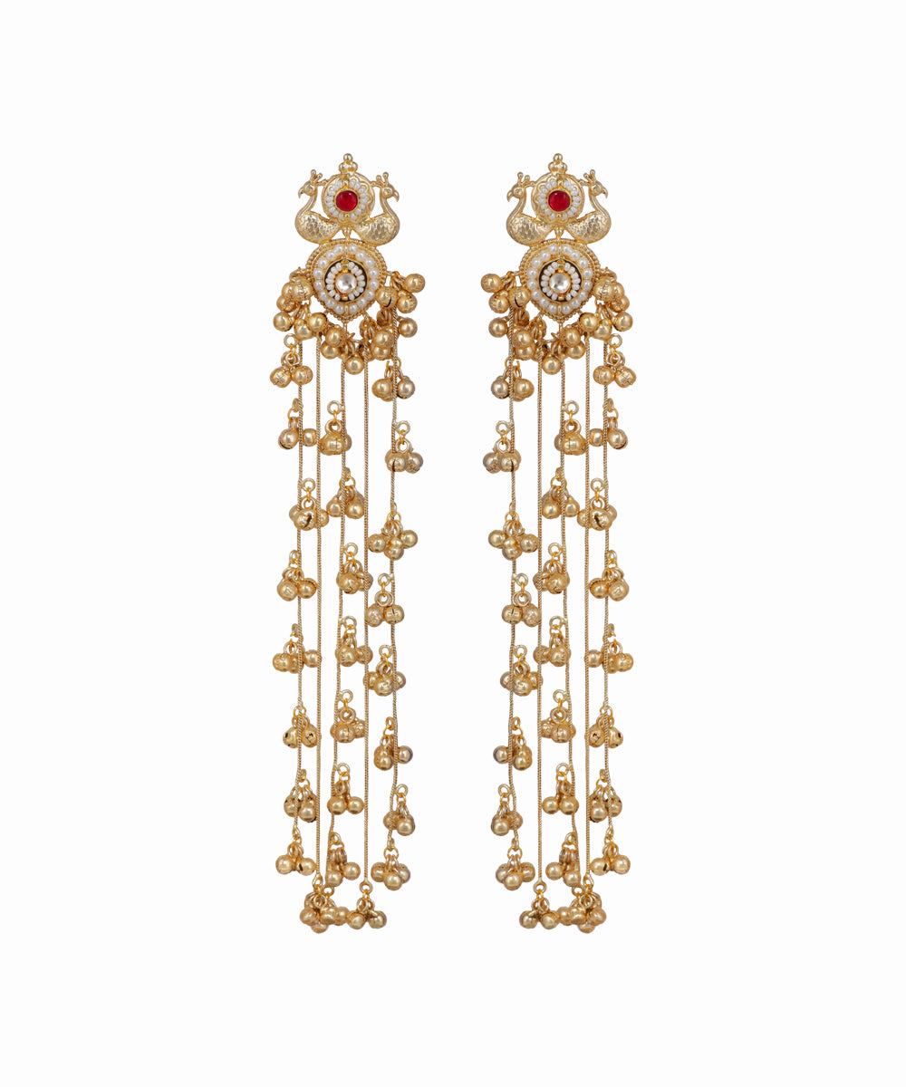 Pair of gold earrings with red gemstones on a white background
