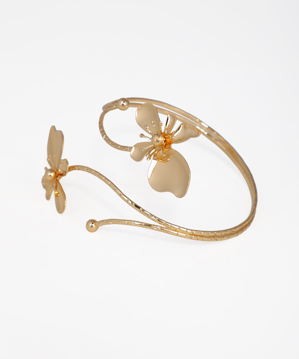 Gold bracelet with butterfly designs on a white background