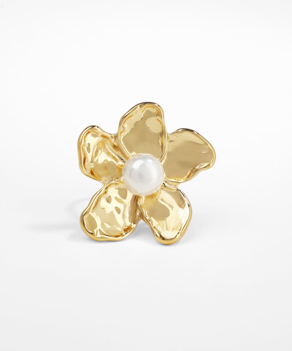 Gold flower-shaped earring with a pearl center on a white background