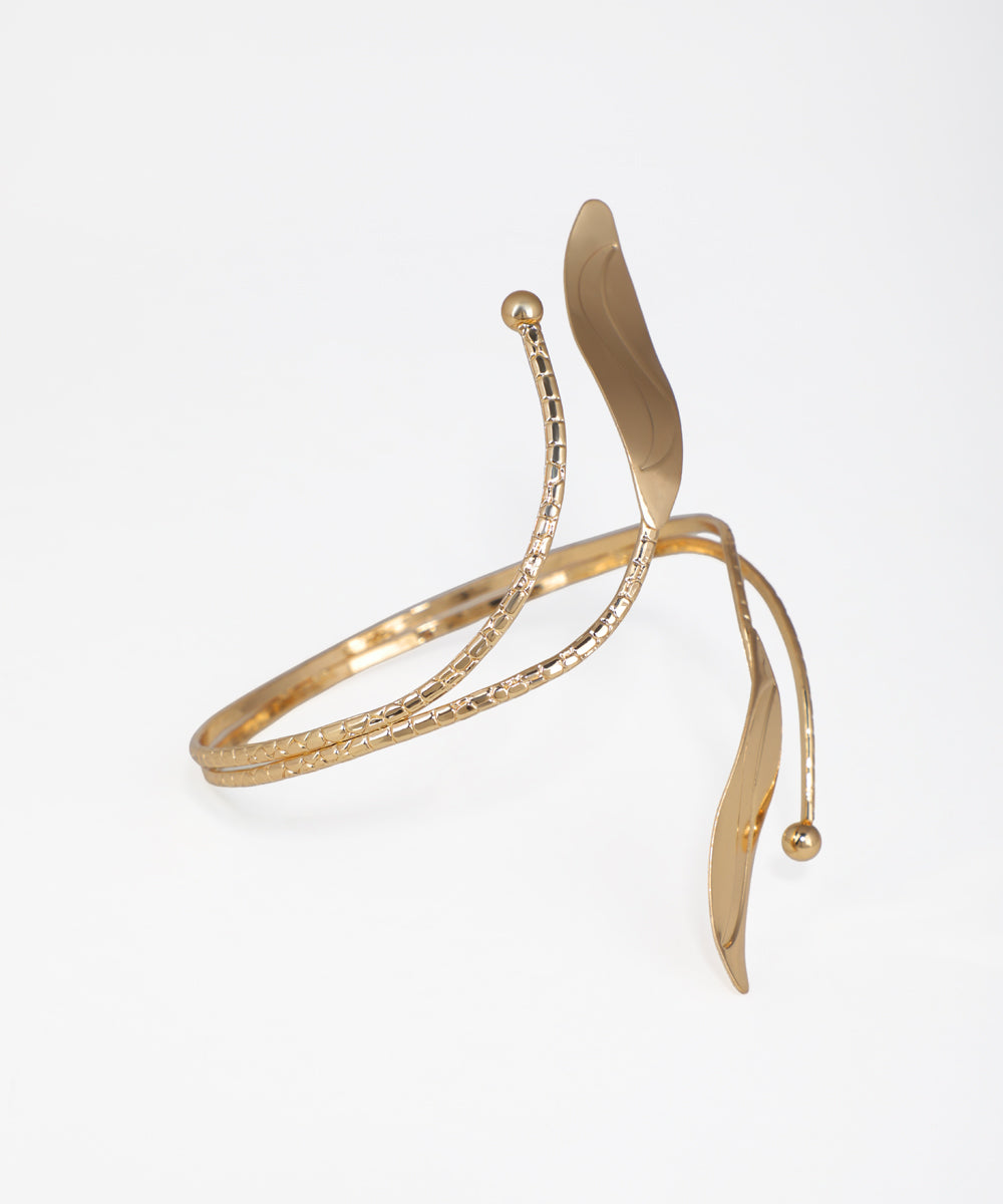 Gold bracelet with a leaf design on a white background