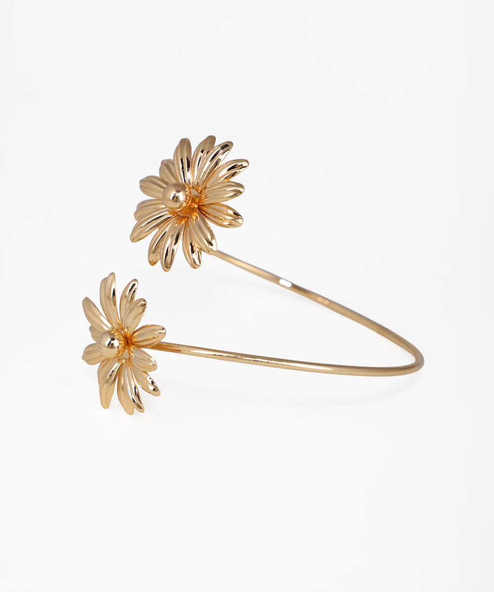 Gold-tone arm cuff with two sculpted floral designs at open ends