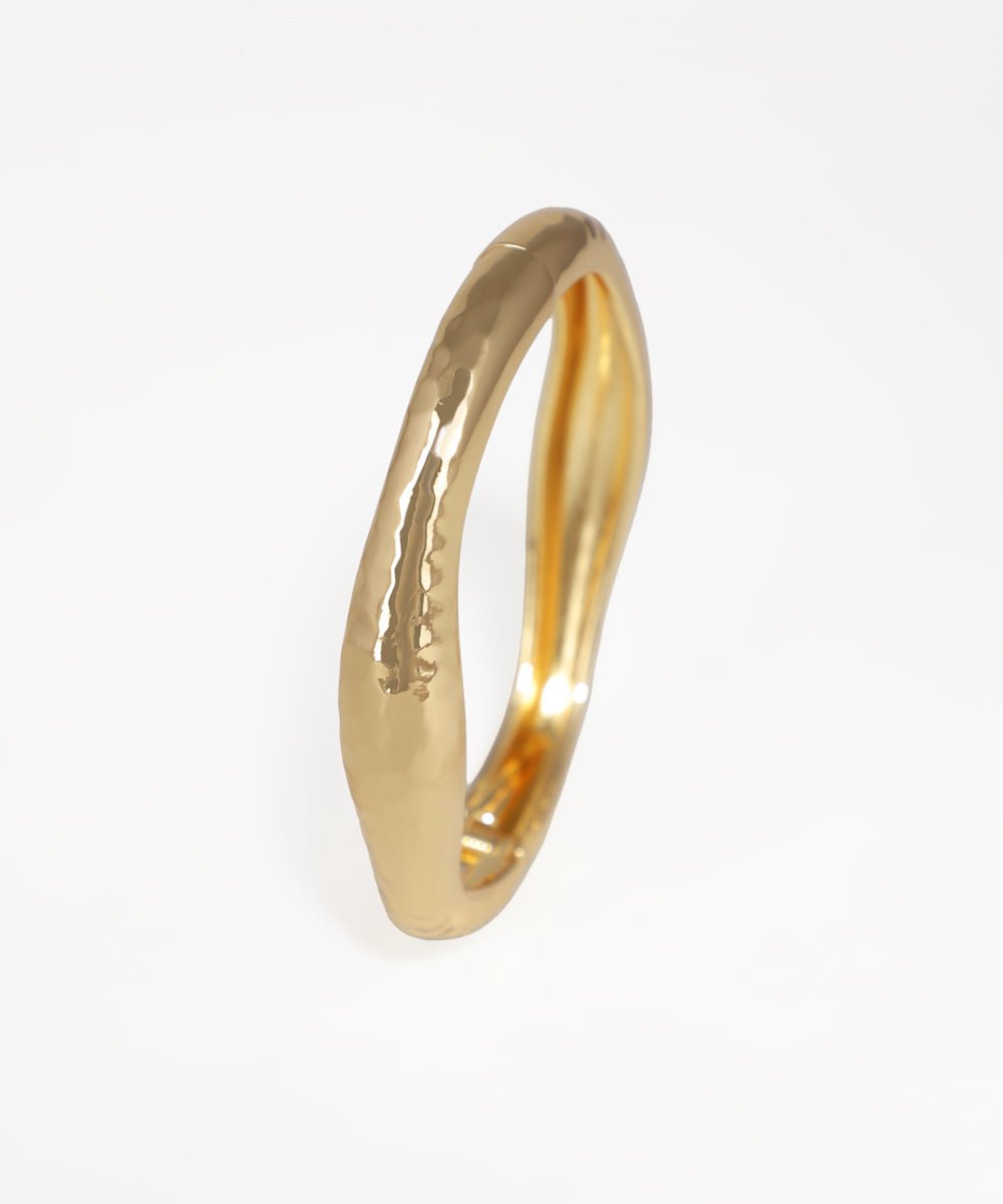 Gold ring with a textured surface on a white background