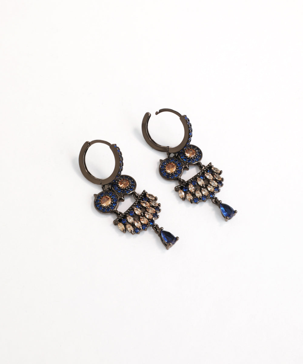 Pair of ornate earrings with blue and gold accents on a white background