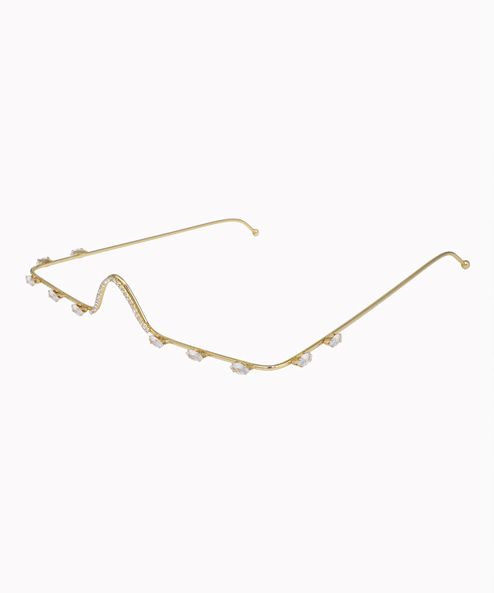 Gold eyeglass frame with small pearls on a white background