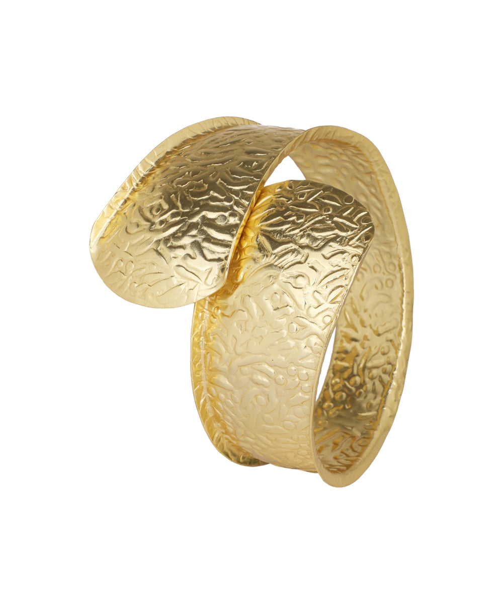 Gold-tone arm cuff with textured surface and overlapping organic design