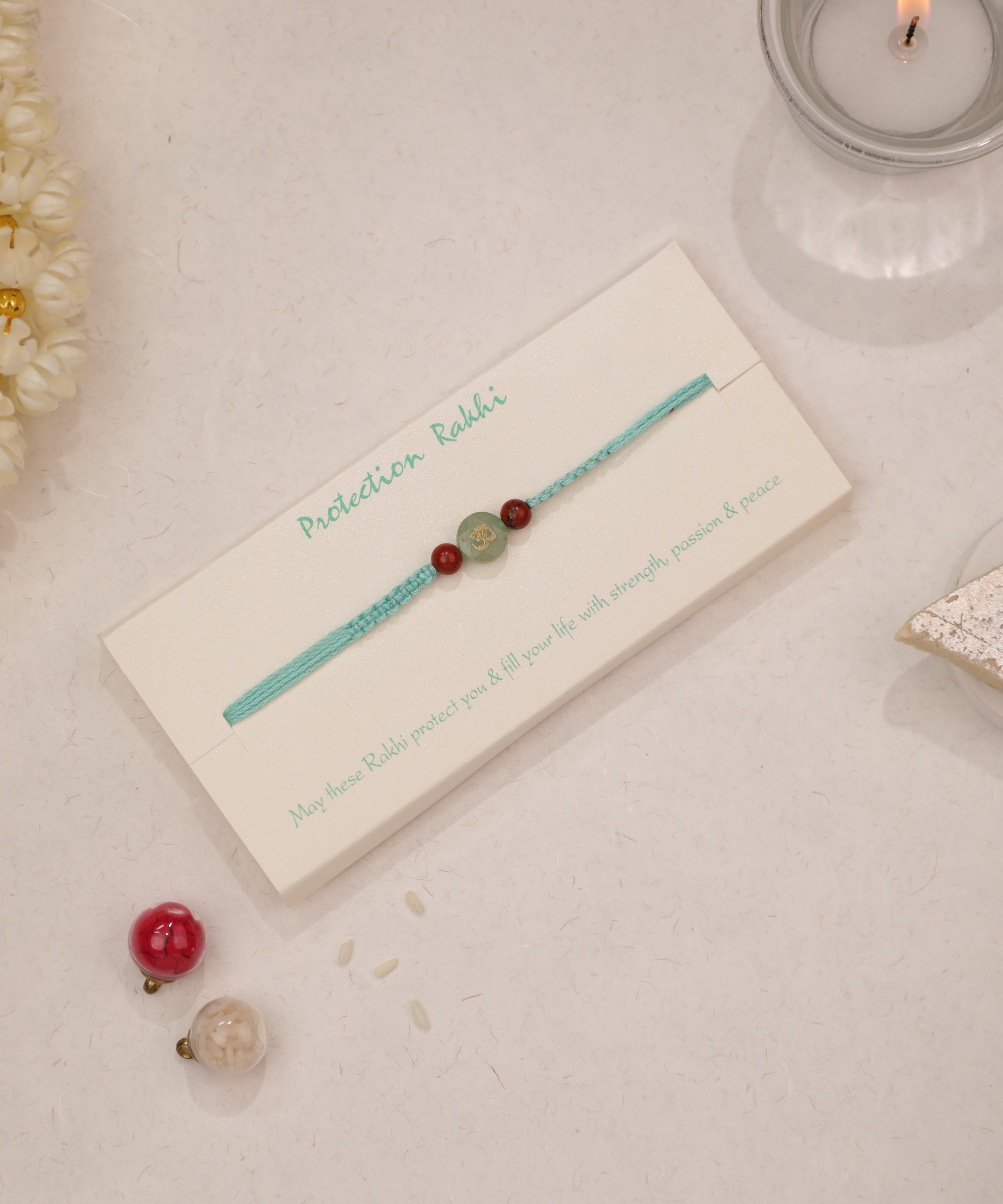 Green and red stone bead thread Rakhi with Om symbol design