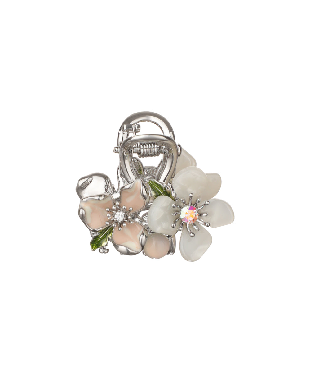 Silver-tone claw clip with enamel pink and white floral cluster, green leaves, and small crystals