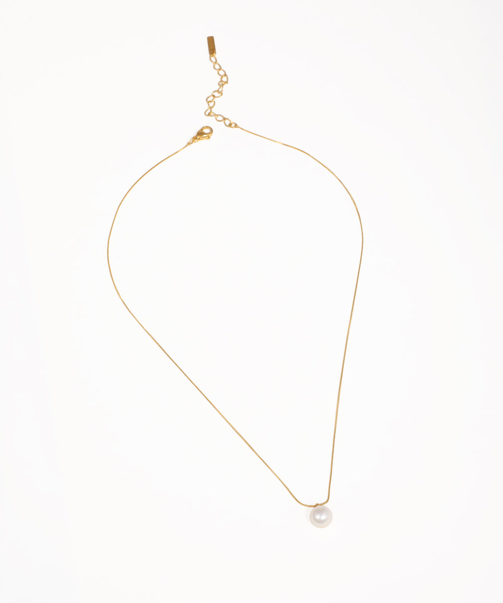 Gold-tone necklace with a fine chain and a single white round faux pearl drop