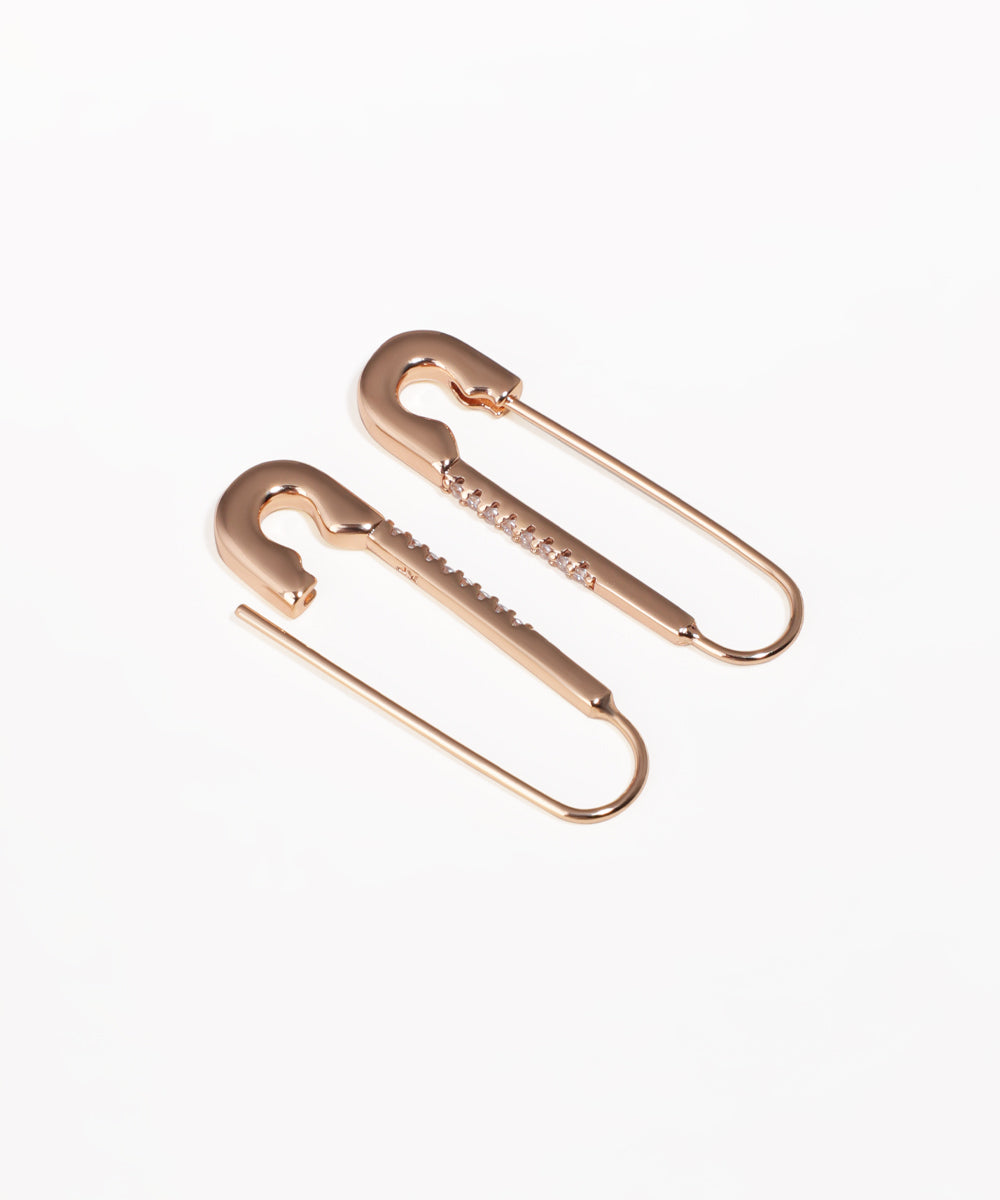 Rose-gold tone drop earrings with safety pin design and embedded clear stones