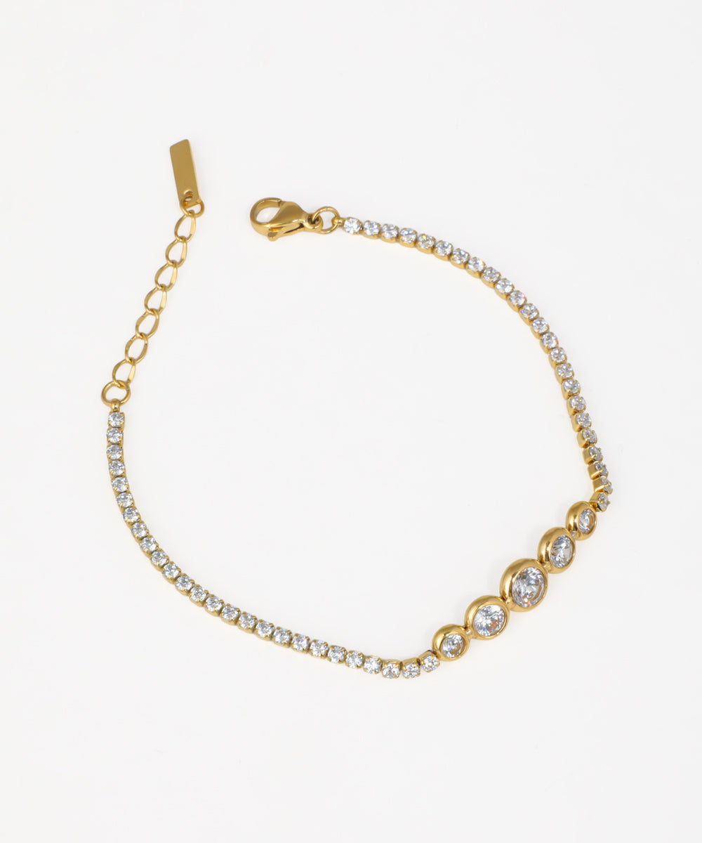 Gold-tone bracelet with graduated bezel-set and line of clear stones