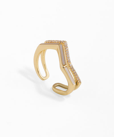 Gold-tone open ring with a chevron design, featuring white inlay and pave-set clear stones.