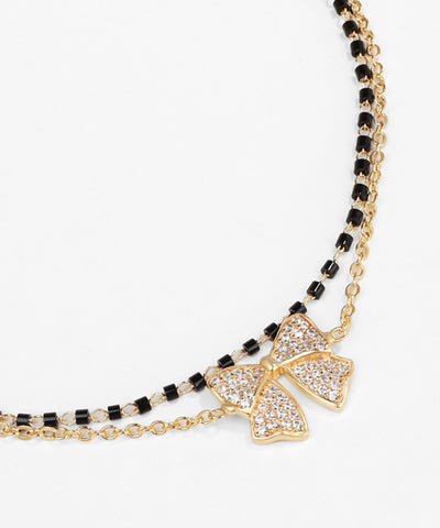 Necklace with a bow pendant and black beads on a white background