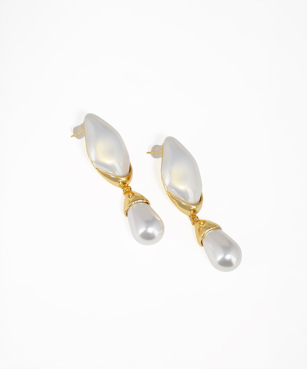 Pearl earrings with gold accents on a white background