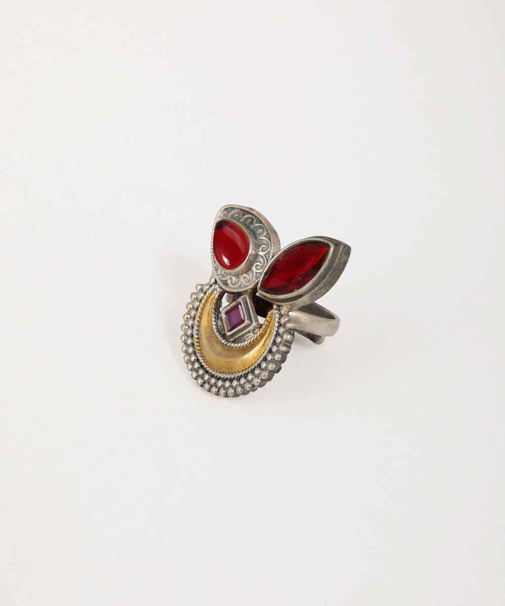 Decorative ring with red stones and gold accents on a white background