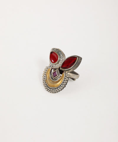 Decorative ring with red stones and gold accents on a white background