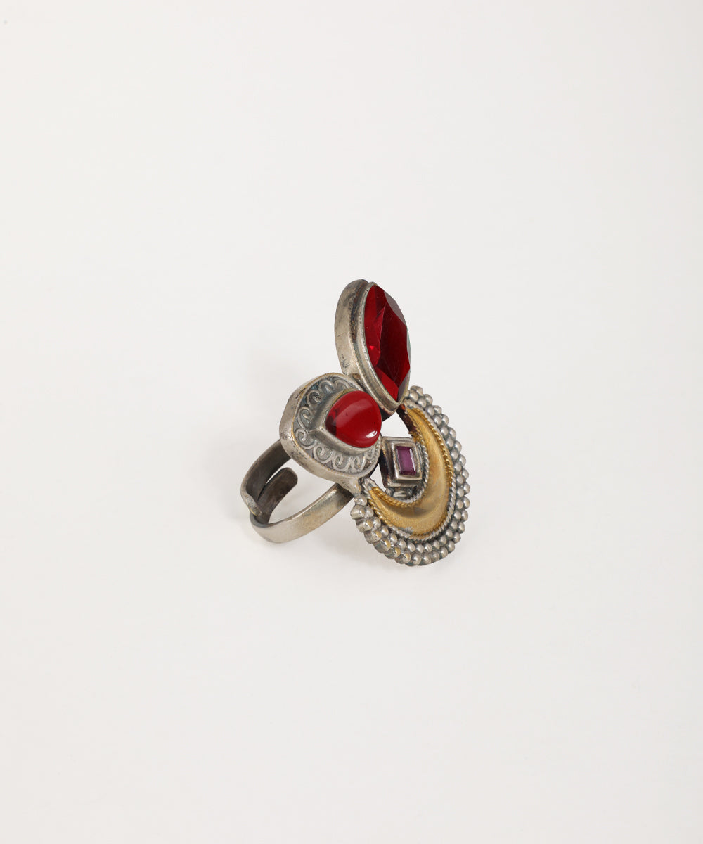 Multicolored ring with red gemstone on a white background