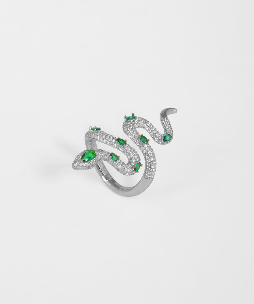 Silver snake-shaped ring with green gemstones on a white background