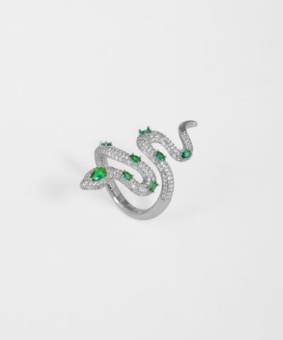 Silver snake-shaped ring with green gemstones on a white background