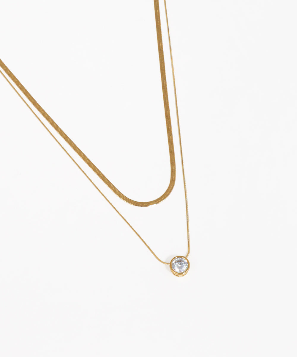 Layered snake chain necklace with solitaire crystal pendant and gold-tone finish