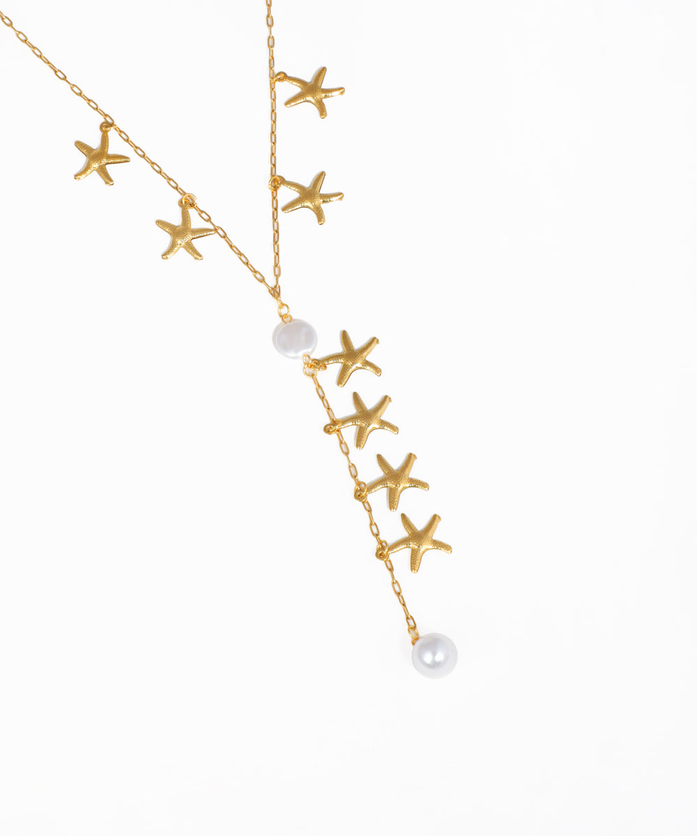 Cascading starfish charm lariat necklace with gold-tone chain and ocean-inspired design