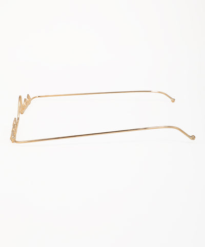 Gold-tone facelet showcasing detailed teardrop ornaments along a wavy frame