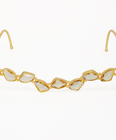 Stylish gold facelet featuring faceted geometric stones along a curved design