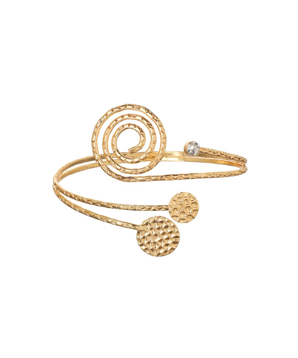 Gold-tone arm cuff with large spiral detail, textured bands, small clear stone, and hammered circular discs.