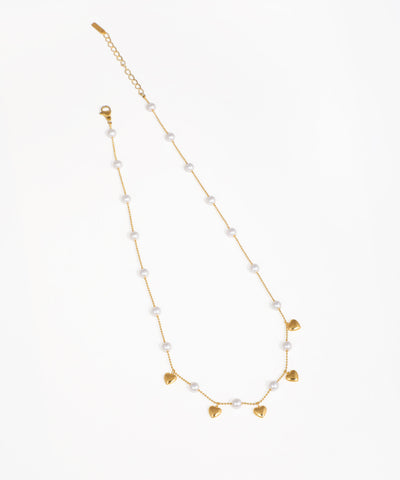 Gold-tone necklace with faux pearls and dangling heart charms.