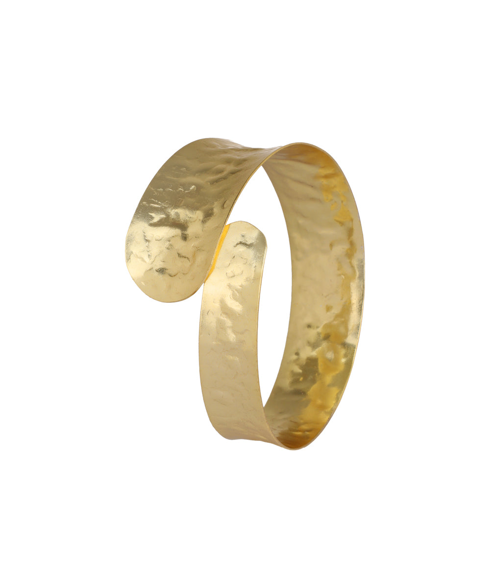 Gold-tone arm cuff with a wide, hammered finish and an open, wave-like design