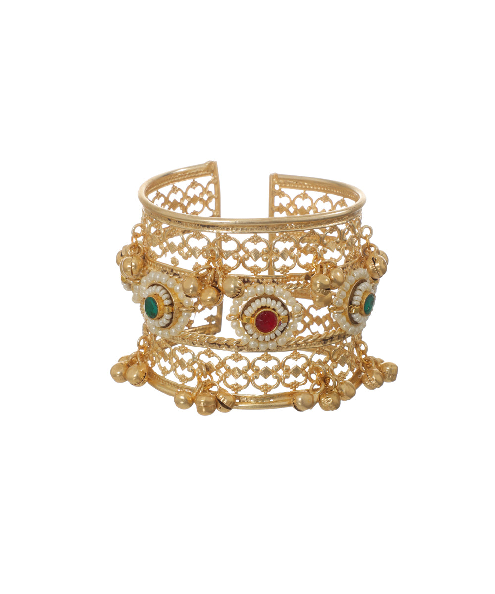 Gold-tone Oxidise cuff bracelet with intricate filigree, faux pearls, green and red stones, and dangling ghungroos.