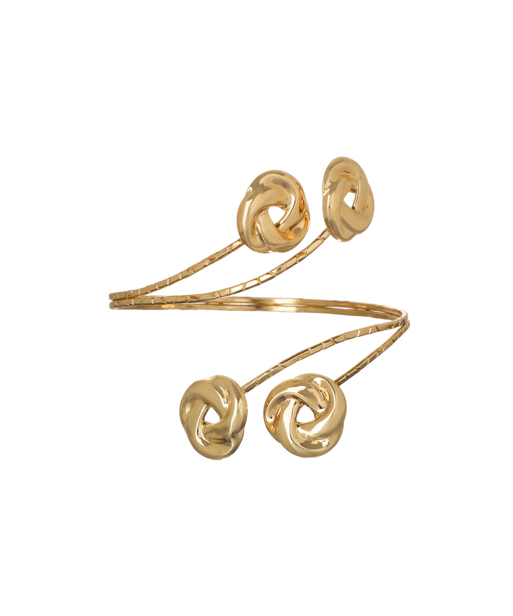 Gold-tone arm cuff with textured spiral band and four sculpted knot details