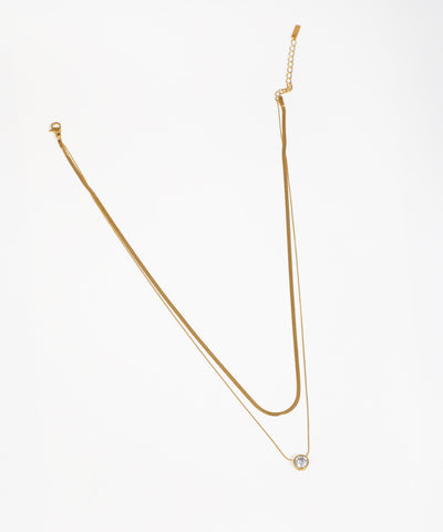 Gold-tone layered necklace with snake chain and round CZ solitaire pendant